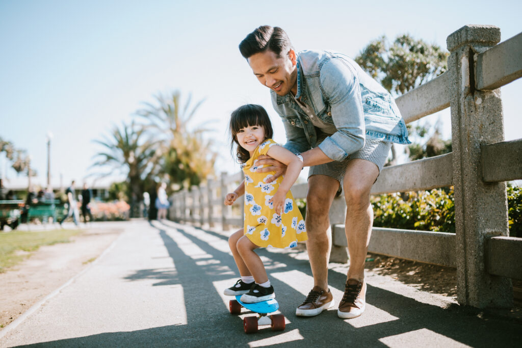 father with daughter on skateboard